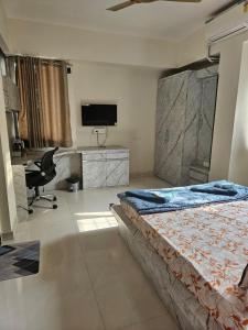 a bedroom with a bed and a desk with a computer at StayGinie Baner in Pune