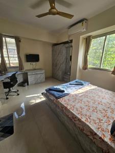 a bedroom with a bed with a ceiling fan and a desk at StayGinie Baner in Pune