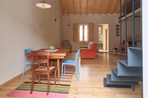 a living room with a wooden table and chairs at Manas Slowliving - Santiago in Santiago do Cacém