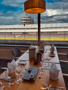 a table with wine glasses and a view of a stadium at Hotel Motodrom in Hockenheim