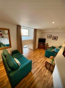a living room with two green couches and a table at Stunning spacious Apartment on River Ness in Inverness