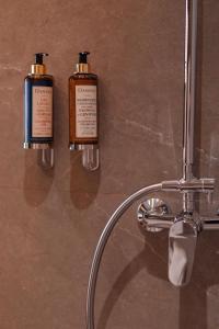 タンジェにあるSuites By Le Rêveのバスルームに備わるボトル入り飲料水2本(壁に設置)