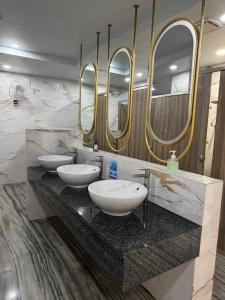 a bathroom with three sinks and three mirrors at The One Chiang Mai 420 - Deluxe 1BDR Pool View near Central Festival in Chiang Mai