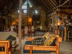 a living room with a couch and tables and chairs at Turtle Cove Self-Catering Lodge & Yoga Shala in Praia do Tofo