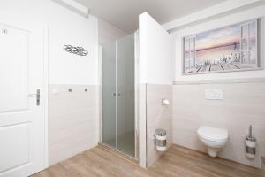 a bathroom with a toilet and a glass shower at Gästehaus "Kleines Stadtidyll" -Zimmer und Apartments in Geesthacht
