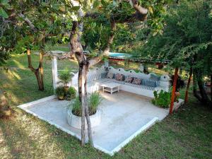 a white couch sitting under a tree in a yard at Turtle Cove Self-Catering in Praia do Tofo