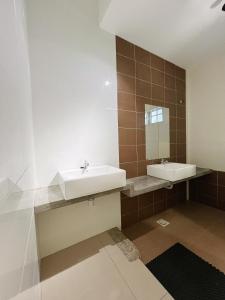 a bathroom with a sink and a mirror at Cozy Family Room with Large Balcony in Nibung Tebal