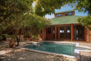 a house with a swimming pool in front of it at Tree House Villa in Praia do Tofo