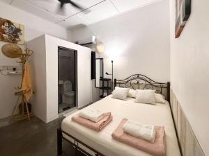 a bedroom with a bed with two pink towels on it at Tiong Nam 32, Heart of Kuala Lumpur, 15mins to KLCC, 6 mins to LRT PWTC in Kuala Lumpur