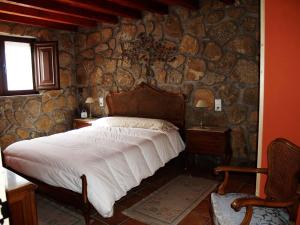 a bedroom with a bed and a stone wall at Escápate y desconecta en Son Soles! in Blacha
