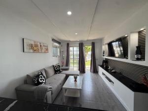 ein Wohnzimmer mit Sofa und Fernseher in der Unterkunft Bungalow Vista Dorada in Sonnenland