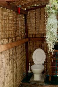 a bathroom with a toilet in a straw wall at Bubble Paradise, Koh ta Kiev in Koh Ta kiev Island