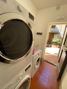 a microwave and a washer and dryer in a kitchen at Glamping Poggio Nardini in Montelupo Fiorentino