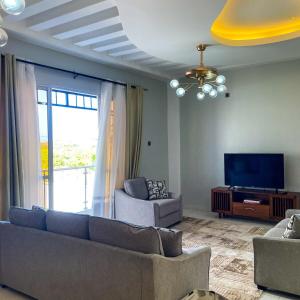 a living room with a couch and a tv at Zuri's Tidehouse, With Beach Access in Mombasa