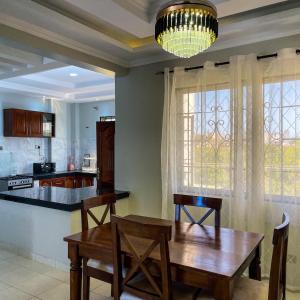 a dining room with a table and a kitchen at Zuri's Tidehouse, With Beach Access in Mombasa