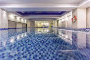 a swimming pool with a blue tile floor at Shkoder Grand Hotel Europa, Affiliated by Melia in Shkodër