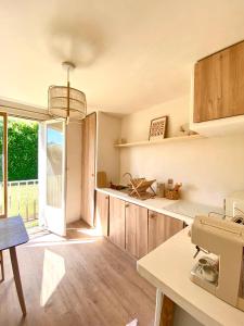 una cocina con armarios de madera y una gran ventana en Studio lumineux, en Évreux