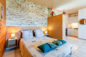 古达尔盖Gîte - Le Samiege的一间带床和石墙的卧室