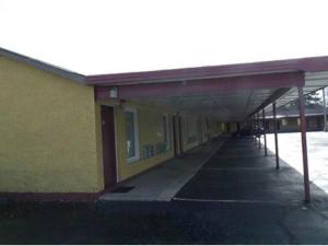 蘭伯頓的住宿－Budget inn，黄色的建筑,旁边设有一条长长的走廊