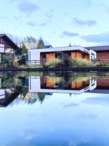 a house is reflected in a body of water at Вудхарт2 in Yasinya