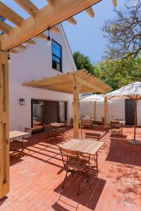 a patio with tables and umbrellas on a brick patio at Minserie Collection in Stellenbosch