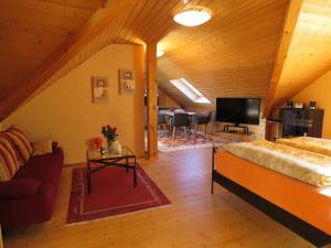 a living room with a bed and a tv at Das blaue Haus in Pleisweiler-Oberhofen