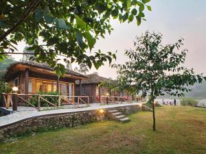 a house with a tree in front of it at Lake Chahafi Resort in Kisoro