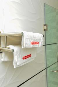 a pile of towels on a towel rack in a bathroom at Triple Tee Luxury Hotel & Service Apartments Surulere in Lagos