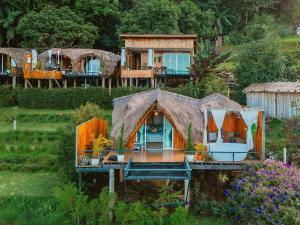 a small house with a thatched roof at ดานบนดินCamping in Ban Thung Phan Ha