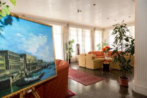 a living room with a painting of a city at Hotel Smeraldo in Lido di Jesolo