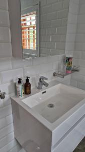 a white bathroom with a sink and a mirror at 40 on Longmarket in Stanford