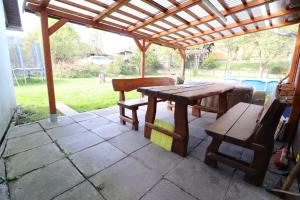 a wooden table and bench under a wooden pergola at Chata pod Paluchem in Vsetín