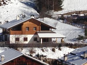 two people standing on top of a house in the snow at Haus Traudi in Nova Ponente