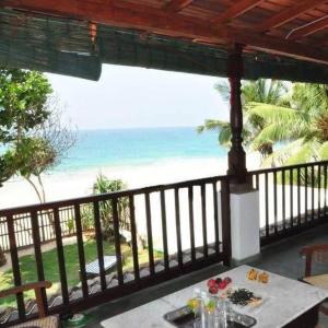une table sur un balcon avec vue sur la plage dans l'établissement Villa Camellia Garland, à Wenamulla