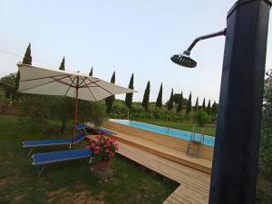 a patio with a bench and an umbrella and a pool at Casa Vacanze Mongili - Il Moro in Chiusi