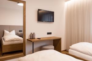 a bedroom with a desk and a tv on the wall at Obergasserhof Apt Gipfelstürmer in Riscone