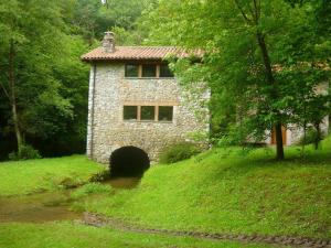 a stone house on a hill with a tunnel in front at Apartamentos Playa La Franca in La Franca