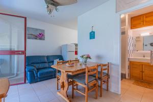 a kitchen and dining room with a wooden table and chairs at Gite les Moussaillons in Hourtin