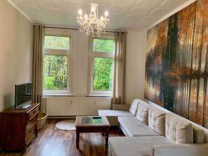 ランゲスハイムにあるFerienwohnung Sagenhaftの白いソファとシャンデリアのあるリビングルーム