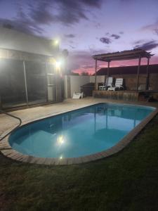 a large swimming pool in a yard at night at Anique's Guest house in Beaufort West