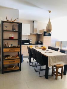 een keuken en eetkamer met een tafel en stoelen bij Appartement Cocooning-sauna-jacuzzi in Vaujany