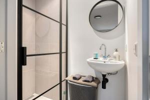 a bathroom with a sink and a mirror at Comfortable 1-Bedroom Flat in Central Rotterdam in Rotterdam