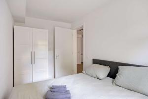 a bedroom with a white bed with a gray headboard at Comfortable 1-Bedroom Flat in Central Rotterdam in Rotterdam