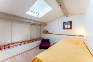 een slaapkamer met een bed en een dakraam bij Gite de Camp chéri in Sommières +16 foto's