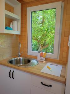 una cocina con fregadero y ventana en Mobile Tinyhouse 2 by Wolfsberger, en Mayrhof