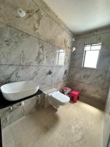 a bathroom with a sink and a toilet at Savitri villa inn in Mahabaleshwar