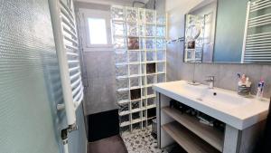 a bathroom with a sink and a shower with a window at La casemate in LʼIsle-sur-la-Sorgue