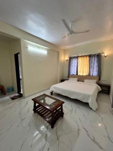 a bedroom with a bed and a coffee table at Savitri villa inn in Mahabaleshwar