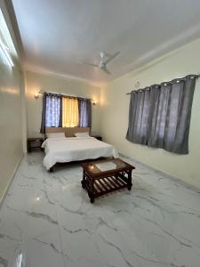 a bedroom with two beds and a table in it at Savitri villa inn in Mahabaleshwar