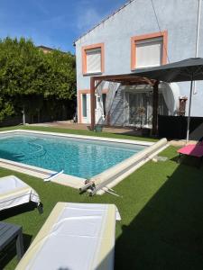 a swimming pool with an umbrella next to a house at La casemate in LʼIsle-sur-la-Sorgue +2 photos